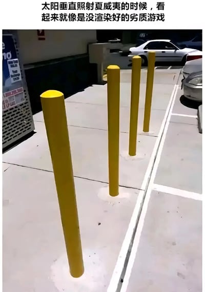 一张停车场场景的照片，画面中有几根黄色的路桩整齐排列在地面上，背景能看到停放的汽车和建筑物。照片上方配有文字：'太阳垂直照射夏威夷的时候，看起来就像是没渲染好的劣质游戏'。这张图通过真实场景中阳光直射造成的特殊光影效果，幽默地调侃其视觉效果类似于早期3D游戏中未完善的渲染画面，给人一种不真实的、像素化的视觉感受。