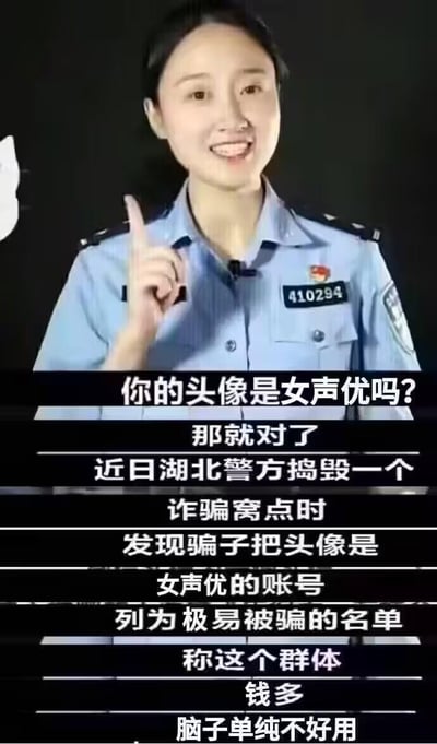 这是一张反诈宣传类的图文内容，画面主体是一位面带微笑、身着警服的女民警，她用手指向上方，正在进行反诈提示。下方配文揭露了湖北警方捣毁诈骗窝点时发现的套路：诈骗分子将使用女声优头像的账号列为极易被骗的名单，认为该群体“钱多、脑子单纯不好用”，以此提醒这类人群提高警惕，防范网络诈骗。