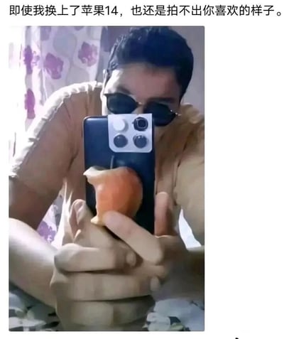 这是一张充满创意的搞笑梗图，图中人物戴着墨镜，双手握持一个改造的道具模仿拿手机自拍的动作：道具的摄像头区域用白色贴纸模仿苹果14的多摄像头模组，下方还固定了一个被咬过的水果苹果，将“苹果”的两种含义（苹果品牌手机与水果苹果）具象化。搭配上方的配文“即使我换上了苹果14，也还是拍不出你喜欢的样子”，运用双关梗制造出荒诞又戏谑的反差感，调侃即使更换了新款苹果手机，也无法满足他人的期待，用趣味化的方式传递出无奈的情绪。