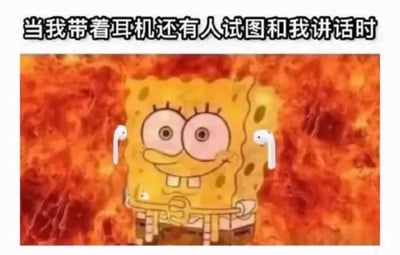 这是一张经过二次创作的网络梗图，主体是经典动画角色海绵宝宝，创作者为其P上了白色的AirPods耳机，背景替换为熊熊燃烧的火焰。海绵宝宝呈现出表情僵硬、眼神发直的状态，脸上挂着不自然的假笑，双手攥在胸前，姿态紧张又抗拒。图片顶部配有文字“当我带着耳机还有人试图和我讲话时”，用夸张的视觉效果和贴合日常的文字，精准地表现出人们在沉浸于耳机中的内容时，被他人突然搭话的烦躁、无奈甚至有点崩溃的情绪，这种场景很容易引发大众的共鸣，常被用来调侃生活中被打断沉浸状态的时刻。