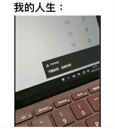 图片展示了一台笔记本电脑的屏幕，上面显示百度网盘的下载结果："下载完毕，全部失败"。图片上方配有文字"我的人生："，通过将人生比喻为全部失败的下载任务，用幽默自嘲的方式表达生活中诸事不顺的感受。
