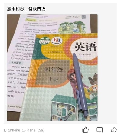 图片展示了一个幽默场景：一本小学四年级英语教科书（三年级起点上册）上放着一支钢笔，旁边还有英语阅读理解练习材料。上方文字写着"嘉木相思：备战四级"，通过使用小学教材准备大学英语四级考试，形成鲜明对比，制造出幽默效果，反映了学生备考时的调侃心态。