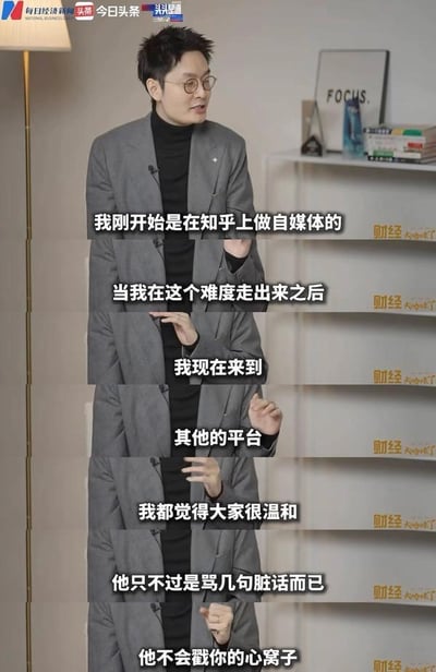 图片为多帧竖屏拼接的视频截图，内容是一位身穿灰色西装、内搭黑色高领毛衣的男性在室内访谈场景中发言。背景可见落地灯、白色书架（摆放书籍、蓝色瓶装物品及写有“FOCUS.”的装饰画）。人物通过手势辅助表达，画面叠加白色文字为其口述内容：“我刚开始是在知乎上做自媒体的”“当我在这个难度走出来之后”“我现在来到其他的平台”“我都觉得大家很温和”“他只不过是骂几句脏话而已”“他不会戳你的心窝子”，整体展现了从知乎起步的自媒体创作者对不同平台用户互动氛围的对比感受。