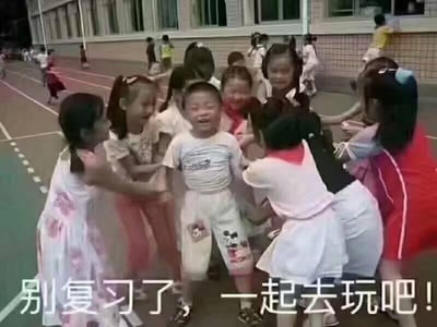 傍晚的学校操场上，一群穿着裙子的小女孩正围着一个身穿白色米奇图案套装的小男孩，孩子们脸上都洋溢着开心的笑容，互相推搡打闹，气氛十分欢乐。背景中还有其他孩子在跑道上活动，教学楼的灯光已经亮起。图片底部配有文字“别复习了，一起去玩吧！”，用孩子们纯真的玩耍场景幽默地表达了希望暂时放下学业、享受轻松时光的心情，展现了无忧无虑的童年氛围。