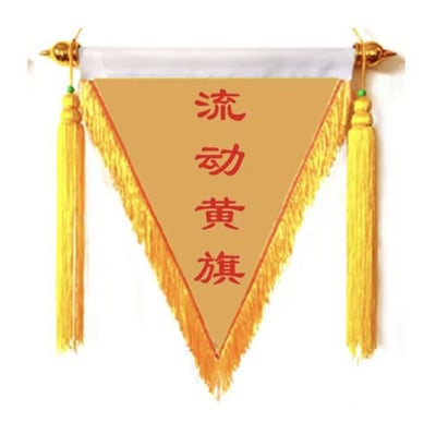 图片中展示了一面三角形的锦旗，旗面为金黄色，边缘有橙色镶边和金色流苏装饰。锦旗中央用红色字体写着“流动黄旗”四个汉字。锦旗通过金色挂钩悬挂，整体设计具有传统中式装饰风格。