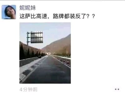 这是一张社交媒体（推测为微信朋友圈）的截图，发布者“妮妮妹”发布了一段吐槽文字和一张高速公路实拍照片。文字内容为“这萨比高速，路牌都装反了？？”，照片展示了一条向前延伸的高速公路，道路上方悬挂着一个朝向对向车道的路牌。实际上该路牌是为对向车道的车辆提供指示的，并没有装反，发布者因误解路牌的朝向而闹了乌龙，这段内容属于生活中的搞笑乌龙事件，体现了对道路指示牌功能的认知误区。