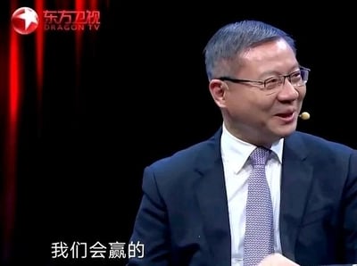 这是东方卫视某访谈类节目的视频截图，画面中的人物是学者张维为，他身着西装、佩戴眼镜，面带微笑侧头看向一旁，神情笃定。画面底部配有字幕‘我们会赢的’，传递出强烈的信心，常被网友用作表达对某件事抱有必胜信念的梗图。