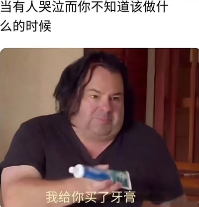 图片上方配有文字“当有人哭泣而你不知道该做什么的时候”，下方是一位表情略显困惑的真人男性，他手持一管牙膏，图片底部叠加文字“我给你买了牙膏”。整体通过反差感制造幽默效果，用送牙膏这种与安慰哭泣者完全不相关的行为，调侃人们在面对他人情绪时的手足无措与社交尴尬。