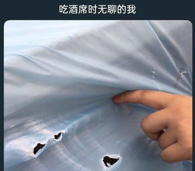 这是一张文字加注的实拍图，图片上方配有文字“吃酒席时无聊的我”，画面中一只涂有红色指甲油的手指正戳在蓝色的塑料桌布上，桌布被戳出了几个形状类似嘴巴的破洞，通过这种玩桌布的细节，生动地表现出在参加酒席时无聊到打发时间的状态，充满生活调侃的趣味。