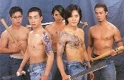 图片中五位男性赤裸上身，仅穿着牛仔裤，每人手持一根木棍，整齐地站成一排。他们姿态挺拔，表情严肃，部分人身上有纹身图案，整体呈现出充满力量感的视觉效果。
