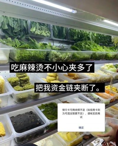 图片展示了一个装满新鲜蔬菜和麻辣烫食材的冷藏柜，里面整齐摆放着各种绿叶蔬菜、玉米、面条等食材。图片上叠加了两行黑色背景白色文字：'吃麻辣烫不小心夹多了'和'把我资金链夹断了'，底部还有一个模拟的银行卡余额不足提示框，写着'银行卡可用余额不足（如信用卡则为可透支额度不足），请核实后再试'并配有'确定'按钮。

这张图通过双关语制造幽默效果，将吃麻辣烫时不小心夹取过多食材导致花费超预算的情况，夸张地比喻为'资金链断裂'，用金融术语形容日常消费场景，形成反差萌笑点。
