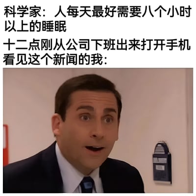 图片上半部分为黑色文字，内容是“科学家：人每天最好需要八个小时以上的睡眠 十二点刚从公司下班出来打开手机看见这个新闻的我：”，下半部分是电视剧《办公室》（The Office）中角色迈克尔·斯科特（Michael Scott）的剧照截图。他穿着深色西装、白色衬衫和蓝色领带，表情震惊，眼睛瞪大，嘴巴微张，背景是浅色墙壁和一个蓝色的物件。通过文字与图片的结合，幽默地表达了职场人因加班导致无法满足科学睡眠时长的无奈与现实反差。