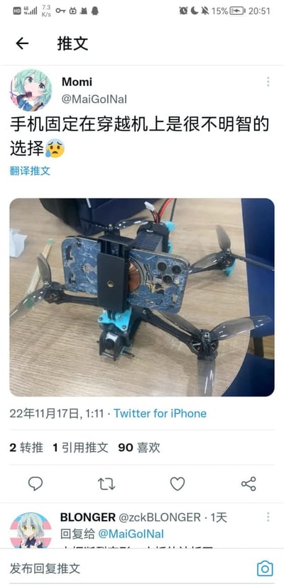 这是一张X（原Twitter）平台的社交媒体截图，截图顶部为手机状态栏，主体是用户Momi（账号@MaiGolNal，头像为二次元绿发少女古明地恋）发布的推文，配文为“手机固定在穿越机上是很不明智的选择”并搭配带汗珠的难过表情，推文下方的配图展示了一台放置在木质桌面上的穿越机，穿越机的支架上固定着一台背面完全碎裂、内部结构外露的损毁手机，直观展现了将手机固定在穿越机上飞行造成的严重后果。该推文发布于2022年11月17日1点11分，发布端为Twitter for iPhone，共获得2次转推、1次引用转推、90个喜欢，截图底部还显示了用户BLONGER的回复入口。