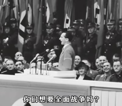 这是一张经过文字加注的二战历史黑白照片，画面中纳粹德国宣传部长约瑟夫·戈培尔站在演讲台后，对着台下的民众与身后列队的纳粹军官激昂演讲。图片底部添加了中文文字“你们想要全面战争吗？”，这句话是戈培尔1943年2月18日柏林体育宫演讲中的标志性提问，目的是煽动德国民众支持继续进行战争。