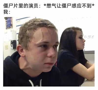 这是一张用于调侃的网络梗图，采用图文结合的形式呈现。上方文字分为两部分，第一行是“僵尸片里的演员：*憋气让僵尸感应不到*”，描绘出影视中演员轻松憋气躲避僵尸的场景；第二行以“我：”引出下方的实拍图片。图片里前景的男生正用力憋气，脸部涨红，额头和脸颊憋出纹路，颈部肌肉紧绷，表情窘迫又用力；背景的女生神态自然地坐着，两者形成鲜明对比，夸张地表现出普通人尝试模仿电影里的憋气操作时的艰难与狼狈，通过现实与影视内容的反差制造出强烈的搞笑效果。