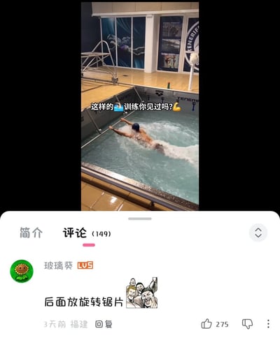 图片展示了一个室内游泳池场景，一名戴着蓝色泳帽的男子正在泳池中向前游泳，水花四溅。画面上方有白色文字覆盖：“这样的🏊训练你见过吗？🤔”。图片下方是社交媒体的评论区界面，当前选中“评论 (149)”标签，显示一条高赞评论：用户“玻璃葵”（LV5）发布的“后面放旋转锯片”，并配有一张四人开怀大笑的卡通插图，该评论获275个赞，发布于3天前，地点显示为福建。整体内容以游泳训练场景为引子，结合幽默评论形成趣味互动效果。