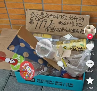 这是一张来自微博的社交媒体截图，画面主体是一个印有“得到运动·潮流·好物 CAN'T STOP WON'T STOP”字样的蓝色鞋盒，鞋盒内装满了各类吃完喝完的废弃包装，包括蜜雪冰城的饮品杯、空奶茶杯、饮料罐、塑料袋装的杂物等。鞋盒上方立着一块手写纸板，内容为“今天是我和初恋分开的第999天 我好想她 希望大家送点礼物安慰”，以此为由头向路人“求安慰”。图片右侧显示该内容的社交互动数据：19.1万点赞、6.5万评论、2785次收藏，还有发布者的猫咪头像。图片中间带有微博用户“@liu_iiiiirich”的水印，整体内容充满搞笑反差感。
