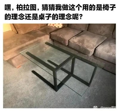 这是一张静态单图，属于视觉错位的原始拍摄图，画面展示了一个放置在灰色地毯上的家具，该家具由黑色金属框架和透明玻璃构成，背景是一套深灰色的L型沙发。这个家具利用视觉错位的设计，从当前视角观察，既可以被识别为一张供放置物品的低矮桌子，又可以被看作是一把可供人落座的椅子，模糊了两种家具的明确边界。图的上方配有文字：“嘿，柏拉图，猜猜我做这个用的是椅子的理念还是桌子的理念呢？”，这段文字是在调侃古希腊哲学家柏拉图的“理念论”——柏拉图主张在现实世界之外存在一个完美的理念世界，现实中的事物都是对理念世界中对应完美原型的模仿，而这个无法被明确归类为桌子或椅子的家具，就对这种“每个事物都有对应完美理念”的理论进行了趣味化的挑战，制造出充满哲学趣味的meme效果。针对图中的问题，从哲学角度可以理解为这个家具同时分有了桌子和椅子的理念，也可以认为它是一个拥有独特理念的新事物，不过这个问题本身是趣味调侃，没有标准答案，核心是用模糊边界的事物来戏谑理念论的绝对化。图片右下角带有“@meme图咖”的水印，表明其传播来源。
