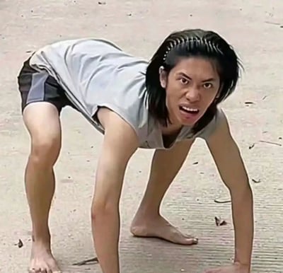 这是一张经过图像拼接P图创作的恶搞图片，将真人的头部与拼接成四足姿态的人体肢体结合，人物面部表情极度夸张，双眼圆睁、嘴巴大张，赤脚以四肢撑地的姿势趴在水泥地面上，整体画面荒诞滑稽，充满恶搞趣味，常被用作表情包来表达激动、抓狂、准备冲刺等强烈的夸张情绪。