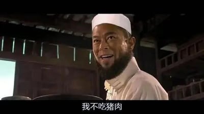 这是一张电影《叶问2：宗师传奇》的截图，画面中是一位戴着白色伊斯兰小帽、留着胡须的男性配角，他面带笑容，下方配有字幕“我不吃猪肉”。这句话契合该角色的穆斯林身份，对应其宗教饮食禁忌，是影片中饭局场景里的一句日常表述，没有双关、谐音梗或暗示内容。