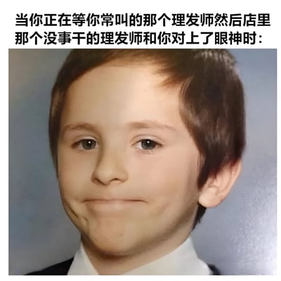 图片上方配有文字描述场景：“当你正在等你常叫的那个理发师然后店里那个没事干的理发师和你对上了眼神时：”，下方是一张儿童的面部照片，孩子嘴角微微上扬，眼神略显不自然，呈现出一种尴尬又无奈的微笑表情，生动还原了人们在理发店遇到不想让其理发的空闲理发师时的窘迫心理状态。