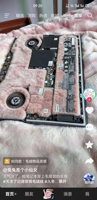 这是一张抖音短视频的截图，用户「兔兔是个小仙女」为了玩梗，模仿天冷加绒保暖的生活习惯，将笔记本电脑后盖拆开，在内部的主板、电池等硬件周边贴上了粉色毛绒布料，给笔记本“穿”上了毛茸茸的“冬装”，完全忽略了笔记本需要散热的基本需求，操作既可爱又离谱，制造出无厘头的搞笑效果。
图中还能看到抖音的界面元素，包括顶部的导航栏、右侧的点赞评论数据，以及底部的文案和话题标签。