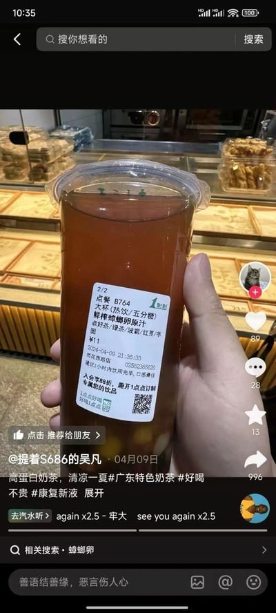 这是一张来自抖音平台的竖屏社交媒体截图，内容为一只手拿着一杯一点点品牌的热饮奶茶，杯身的订单标签被人为修改为“鲜榨蟑螂卵原汁”，标注为大杯热饮五分糖，配料包含绿茶、波霸、红豆、芋圆，售价11元。截图下方的发布者配文玩梗，称其为“高蛋白奶茶，清凉一夏”，并带上了#广东特色奶茶 #好喝不贵 #康复新液 等搞笑标签，相关搜索栏还出现“蟑螂卵”关键词。作者通过将正常饮品名称替换为极具冲击力的恶心词汇，制造出荒诞的反差感，以此达到恶搞搞笑的效果。截图显示该内容发布于2024年4月9日，互动数据可观，点赞89、评论28、收藏13、转发996，引发了不少网友的关注。