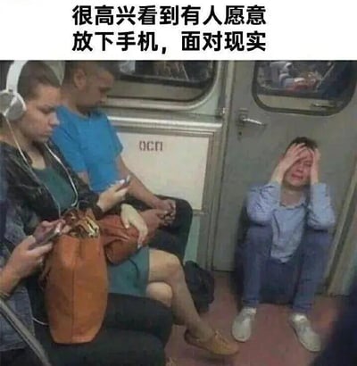 这是一张拍摄于地铁车厢的梗图，画面中大部分乘客都低头专注于手中的手机，沉浸在虚拟世界里；只有车厢角落的一位年轻人放下了手机，双手捂脸，看起来情绪崩溃、十分痛苦。图上方配有文字“很高兴看到有人愿意放下手机，面对现实”，用反讽的手法，调侃当代人普遍依赖手机逃避现实的状态，而这位被迫放下手机的人，却是要直面让自己崩溃的残酷现实，形成强烈的反差，精准戳中当代人在虚拟慰藉与现实压力之间挣扎的困境。