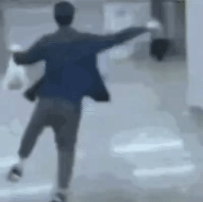 一名男子在室内光滑地面上尝试跳跃障碍物，他张开双臂助跑起跳，身体腾空而起，但跳跃高度不足，导致身体撞到障碍物后失去平衡，在空中翻转半圈后重重摔倒在地面上，整个过程展现了从自信尝试到意外失败的滑稽反差。