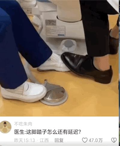图中呈现医院诊疗场景，穿白色医护鞋的医护人员正使用带脚踏的医疗设备，一旁穿黑皮鞋的患者误将脚踩在了设备脚踏上。下方配文评论“医生:这脚踏子怎么还有延迟?”，点出医护人员的误会——以为设备故障有延迟，实则是患者的脚踩住了脚踏，通过生活中的小误会制造出搞笑效果。