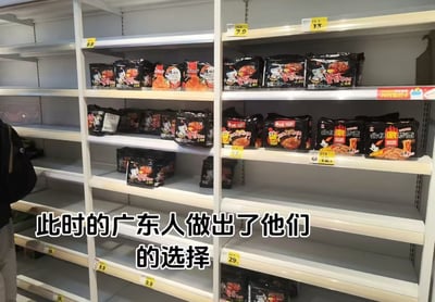 超市货架场景，大部分货架空置，仅剩各种品牌的辣味方便面整齐排列，包括火鸡面、激辣炒面等产品。图片下方有文字标注“此时的广东人做出了他们的选择”，通过广东人不爱吃辣的地域刻板印象制造幽默效果——当货架上只剩辣泡面时，广东人别无选择的无奈场景。