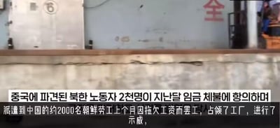 这是一则新闻视频的截图，画面上方展示了工厂的外部场景，可见带有数字“6”的金属门和印有“全”字的墙面，右上角能看到一个人物身影。画面下方配有中韩双语字幕，中文字幕内容为“派遣到中国的约2000名朝鲜劳工上个月因拖欠工资而罢工，占领了工厂，进行了示威”，对应的韩文字幕表达了相同的意思，该截图呈现了一起劳工因欠薪发起维权行动的事件相关内容。