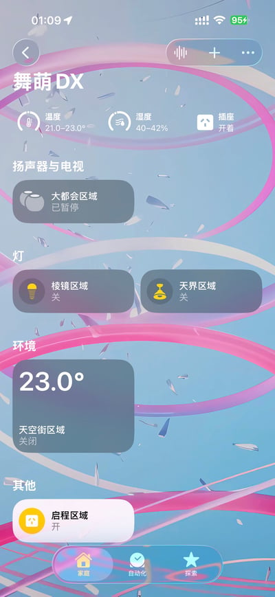 图片展示了一个手机端智能家居控制界面，背景为带有粉紫色曲线的浅蓝色渐变。界面包含环境监测（温度23.0°C、湿度40-42%）、设备控制区域（如扬声器与电视、灯、插座等，部分设备显示“已暂停”或“关”状态），底部有“家庭”“自动化”“探索”三个导航选项。整体布局清晰，信息分类明确，呈现寝室智能设备的控制状态。