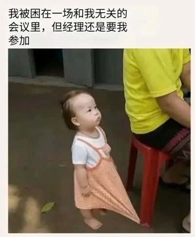 这是一张职场主题的图文混排表情包，采用顶文配图的形式，顶部配文为“我被困在一场和我无关的会议里，但经理还是要我参加”，下方配图是一名穿着白色内搭、橙色围裙的素人幼童，赤脚站在地面上，仰着头露出茫然、无奈、生无可恋的表情，身旁还有一名穿着亮黄色上衣的人坐在红色塑料凳上。幼童的状态精准契合了打工人被强制要求参与和自身无关的无意义会议时的烦躁、无奈又不得不顺从的心态，共鸣感极强。