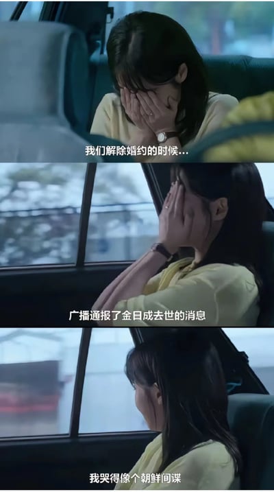 这是一张车内分手场景的影视剧截图三连，女生自述分手时听到广播报道金日成去世，于是自己悲伤大哭，还自嘲“像个朝鲜间谍”。画面展现了主人公强烈伤感和幽默反差。台词通过将私人情感和国际事件荒诞式联系，表达了分手时情感崩溃、哭点离谱的网上吐槽氛围。

梗图最后一句用“朝鲜间谍”进行自嘲、夸张，具有黑色幽默和一定的讽刺意味，也体现了特殊场景下网友的二次创作能力。