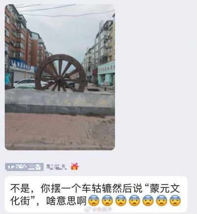 这是一张来自微博的社交媒体截图，上方是网友拍摄的“蒙元文化街”入口场景，街区入口处摆放着一个大型车轱辘造型的雕塑，基座上有模糊的相关标识文字；下方是网友发布的吐槽内容：“不是，你摆一个车轱辘然后说‘蒙元文化街’，啥意思啊”，并搭配了多个疑惑的表情，直白表达了对该文化符号与街区文化定位匹配度的不解，内容无谐音、双关或暗示。