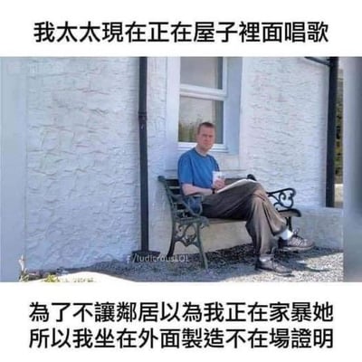 图中是一位表情无奈的男士坐在房屋外的长椅上，手里拿着杯子和一本打开的本子，看起来无精打采。图的上下配有繁体中文文字，上方文字为“我太太现在正在屋子裡面唱歌”，下方文字为“為了不讓鄰居以為我正在家暴她 所以我坐在外面製造不在場證明”。这是一个搞笑吐槽类梗图，用夸张的方式调侃妻子唱歌难听，声音像被家暴时的惨叫，丈夫只能通过待在屋外的方式，避免邻居误会自己在家暴妻子，充满无奈又好笑的反差感，没有双关或谐音梗。