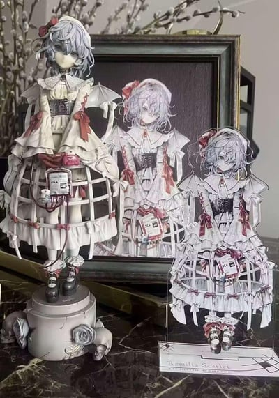 这张图片展示了《东方Project》角色蕾米莉亚·斯卡蕾特的三种衍生呈现形式：左侧是实体手办，采用病弱哥特风格设计，身着破损感白色洋装，身上连接着模拟输血装置，底座搭配骷髅与灰玫瑰装饰，充满暗黑颓废感；中间是装裱在复古画框里的同设计原画；右侧是同款造型的亚克力立牌，立牌底部标注有角色英文名“Remilia Scarlet”。三者摆放在一起，直观呈现了同人设计从原画到实体周边的转化，风格精致又带有病态美学。