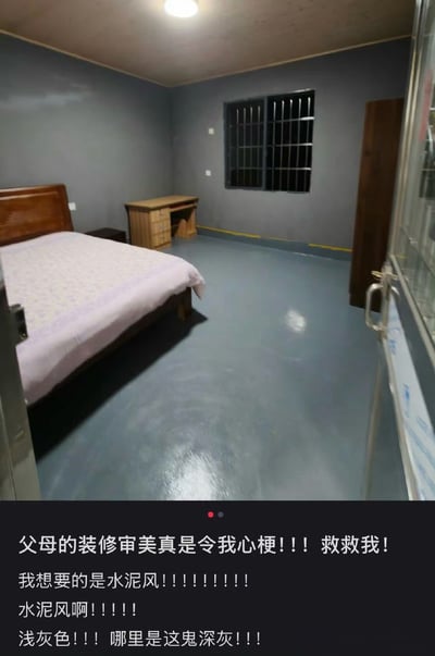 图片展示了一间装修风格引发吐槽的房间：深灰色水泥墙壁搭配带铁栅栏的窗户，地面为光滑水泥地，摆放着木质床和书桌，整体氛围因深色系和铁窗设计被调侃为“监狱风”。图片底部配有文字：“父母的装修审美真是令我心梗！！！救救我！我想要的是水泥风！！！！！！！！水泥风啊！！！！浅灰色！！！哪里是这鬼深灰！！！”，表达了对父母将“水泥风”装成“监狱风”的无奈与崩溃。
双关/暗示：“监狱风”是对深灰色调+铁窗设计的调侃，与期望的“水泥风”（通常为浅灰、简约）形成强烈反差，幽默吐槽父母装修审美与子女期望的巨大偏差。