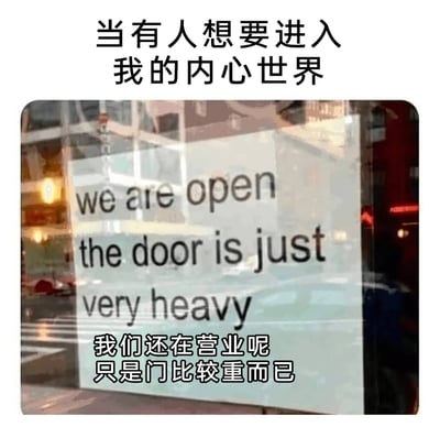 这是一张用来表达社交心理的自嘲梗图，顶部配有中文文字“当有人想要进入我的内心世界”，下方是一张城市街道旁店铺玻璃门的实拍照片，玻璃门上用英文写着“we are open the door is just very heavy”，并配有对应的中文翻译“我们还在营业呢 只是门比较重而已”。图中用“营业的店铺但门很重”这一具象场景，比喻自己的内心世界并非封闭，而是接纳他人的门槛较高，想要走进自己的内心需要付出更多的努力，生动地展现了慢热、内心防备较重但并非拒绝社交的性格状态。