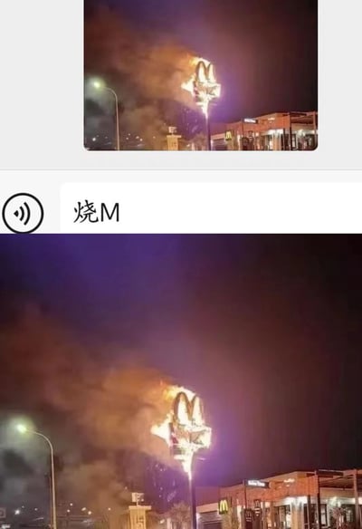 图片展示了麦当劳餐厅的标志性金色拱门在夜间起火燃烧的场景。熊熊火焰吞噬着招牌，浓烟滚滚升入夜空，背景中可以看到麦当劳餐厅建筑和街道灯光。图片下方配有文字"烧M"，是对麦当劳(McDonald's)标志起火这一场景的简洁描述和谐音双关。

双关说明："烧M"中的"烧"指燃烧，"M"既代表麦当劳(McDonald's)的首字母，也与中文"麦"发音相近，形成了巧妙的语言游戏。