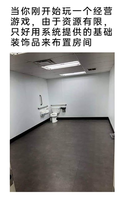 这是一张图文结合的搞笑梗图，上方配有文字“当你刚开始玩一个经营游戏，由于资源有限，只好用系统提供的基础装饰品来布置房间”，下方是一张真实的室内照片：房间空间空旷，墙面为浅灰色素面，地面是深色，仅在角落设置了一套带无障碍扶手的马桶及配套设施，天花板只有基础的嵌入式照明灯具，整体布置极为简陋，仅保留最基础的功能性。这张图用现实中极简的功能性房间，精准对应了经营游戏初期玩家资源匮乏，只能使用系统提供的最低限度基础物品布置空间的窘迫场景，以此调侃经营游戏开局的体验，引发玩家共鸣。
