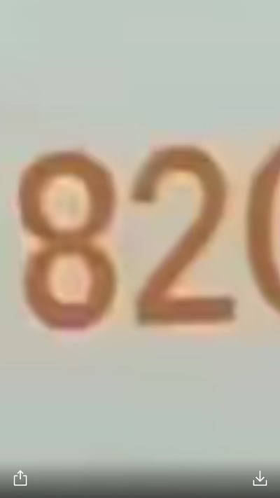 这是一张经过模糊处理的静态截图，画面主体为浅棕色的数字“82”，右侧还露出了另一个数字的部分边缘，整体画面模糊，仅能明确识别出“8”和“2”两个数字，背景为浅淡的纯色，无其他额外元素。