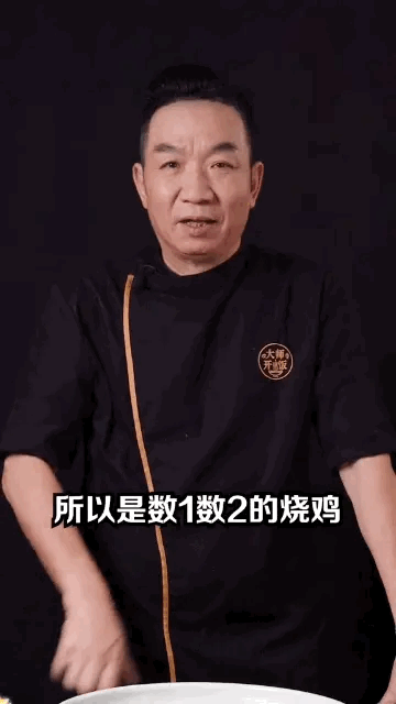 这是一张竖屏的美食类视频截图，画面中一位穿着带有“大师开课”标识黑色厨师服的中年男性厨师，正对着镜头认真讲解，画面下方配有字幕“所以是数1数2的烧鸡”，看起来是在向观众推荐这款烧鸡，强调其品质出众，整体构图清晰，风格专业，没有双关、谐音梗等内容。