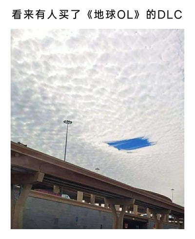 这是一张经过P图改编的趣味梗图，画面下方是城市中的高架桥梁建筑，上方天空被大面积鱼鳞状的云层覆盖，在画面右下角，有一块被修改成类似画笔涂抹开的蓝色天空区域，边缘带有模糊的涂抹痕迹。图上方配文“看来有人买了《地球OL》的DLC”，借用游戏中DLC（可下载内容，通常为新增内容）的概念，将这个奇特的天空效果调侃为“地球OL”这款虚拟的“现实游戏”更新的特殊内容，制造出打破次元壁的趣味感，让现实场景充满游戏化的脑洞趣味。