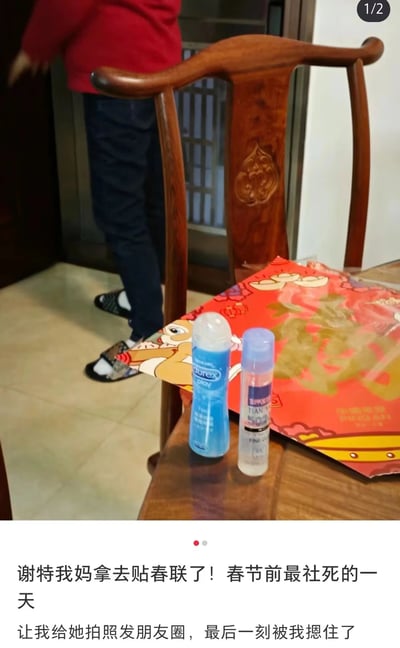 图片展示了一个家庭场景，前景是一把带有雕花的木椅，椅子上放着一张印有卡通图案的红色春联包装纸，上面放着两瓶疑似护肤品的物品（一瓶蓝色、一瓶透明）。背景中，一名穿着红色上衣和深色裤子的人正走向门口，脚上穿着拖鞋。图片下方配有文字描述：“谢特我妈拿去贴春联了！春节前最社死的一天 让我给她拍照发朋友圈，最后一刻被我摁住了”，讲述了妈妈误将桌上物品当作春联相关物品准备张贴，差点拍照发朋友圈导致社死的尴尬瞬间。