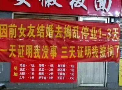 这是一张原始拍摄的街边店铺照片，画面主体是一家名为“安徽板面”的店铺，门口悬挂着一条醒目的红色横幅，上面用黄色字体写着极具搞笑色彩的停业理由：“因前女友结婚去捣乱停业1-3天 一天证明我没事 三天证明我被拘了”，用自嘲式的幽默向顾客告知停业时长和可能的后续情况。横幅下方是店铺的“另加”菜品价目表，列出了鸡蛋、豆皮、火腿、丸子等多种食材的售价，价格从1元到8元不等。整个画面属于图文混排的顶配底文图，没有双关、谐音梗等内容，凭借接地气又搞笑的停业理由，让普通的店铺通知充满趣味。