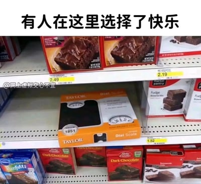 这是一张超市货架的实拍静态图，货架的上层和下层均摆放着Betty Crocker、market pantry等品牌的布朗尼蛋糕预拌粉，价格在1.52美元到2.49美元不等，而在下层货架的蛋糕粉中间，却突兀地放置着一台Taylor品牌的体重秤。图片上方配有文字‘有人在这里选择了快乐’，通过美食（代表享受生活）与体重秤（代表减肥自律）的场景反差，调侃了人们在面对美食诱惑时，选择拥抱美食、放弃自律的快乐选择，充满生活趣味与幽默氛围。