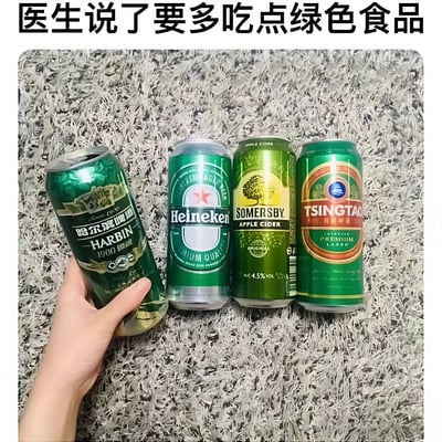 图片上方有黑色加粗文字“医生说了要多吃点绿色食品”，下方是一张实拍场景：灰色地毯背景上并排放置四罐绿色包装的饮品，从左到右依次为哈尔滨啤酒、喜力啤酒、Somersby苹果酒和青岛啤酒，左侧有一只手正握住哈尔滨啤酒罐。图片通过“绿色食品”的双关语义制造笑点——将绿色包装的酒精饮品曲解为健康概念中的“绿色食品”，形成幽默的误解场景。