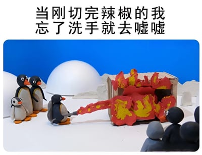 图片上方配有文字“当刚切完辣椒的我忘了洗手就去嘘嘘”，下方是黏土制作的场景：蓝色背景前有几只企鹅，其中一只企鹅正朝着一个小房子喷射红色和黄色的火焰状物质，其他企鹅在一旁围观。通过夸张的黏土动画场景，幽默地表现了切完辣椒不洗手就接触敏感部位后产生的强烈灼烧感。